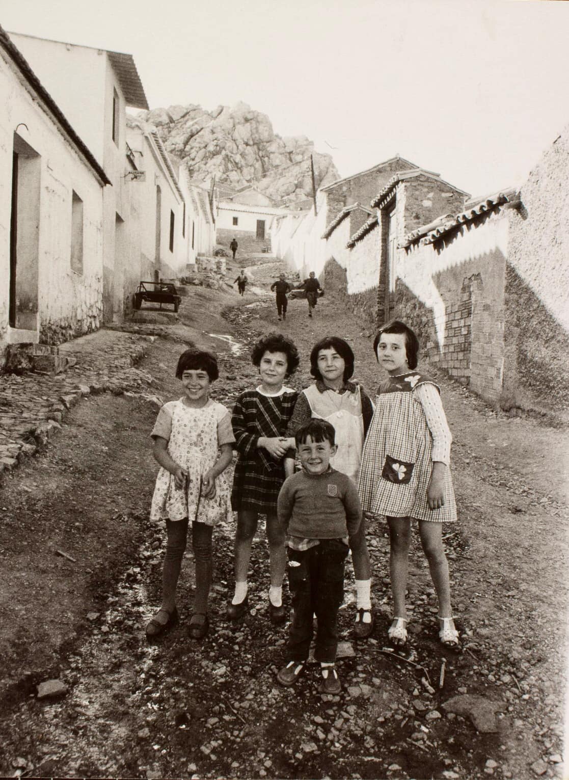 Unas niñas y un peque en una calle empinada y sin asfaltar en la barriada San Sebastián en 1961. Fotografía Oriol Maspons